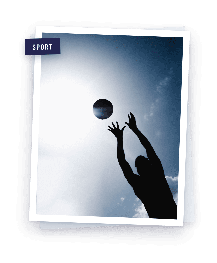 A volleyball player hitting the ball against a clear sky